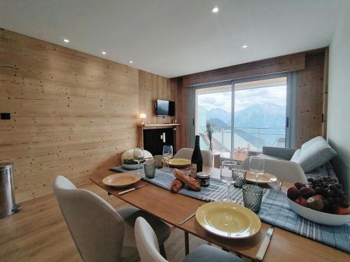 - une salle à manger avec une table et des chaises offrant une vue dans l'établissement Homency - Résidence le Majestic K5, à L'Alpe-d'Huez