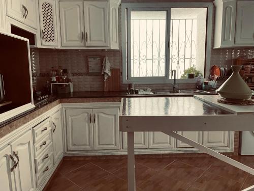 a kitchen with white cabinets and a counter top at Syrah Home in Tangier
