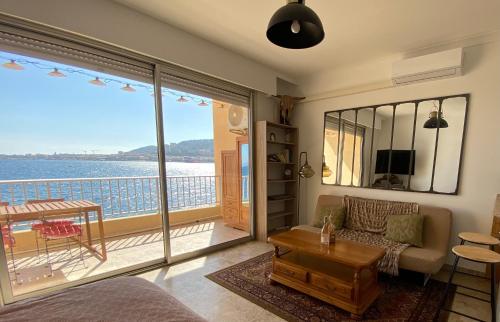 een woonkamer met uitzicht op de oceaan bij Appartement pieds dans l eau in Ajaccio