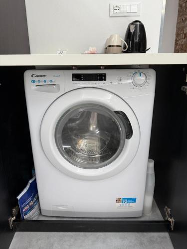 a white washing machine sitting under a counter at City Garden in Rovigo