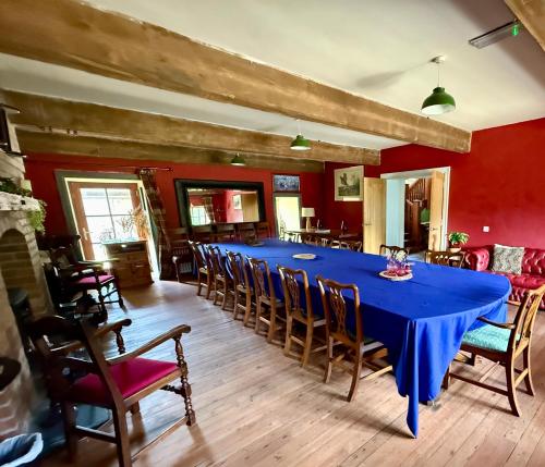 a dining room with a blue table and chairs at The Old Flax Mill Yoga Retreat in Coleraine