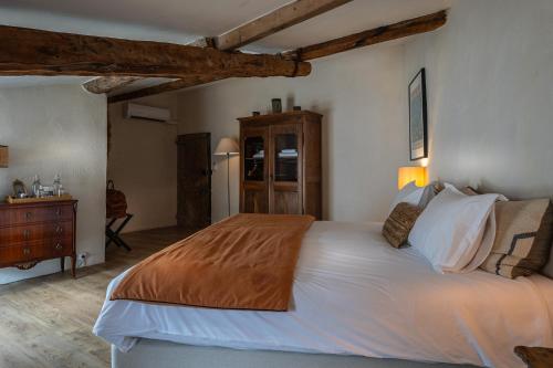 a bedroom with a large white bed and a dresser at La Chapelle sur la Sorgue in LʼIsle-sur-la-Sorgue
