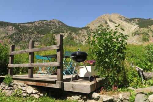 a grill sitting on a wooden platform with mountains in the background at Le Bachasson in Névache