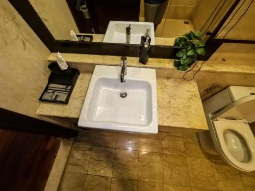 a bathroom with a sink and a toilet at Goldcoast Palm Tree Sepang Luxury Resort in Sungai Pelik