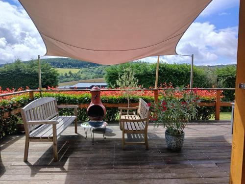 a patio with two chairs and a table with a vase at Ma Cabane du Canada in Combray