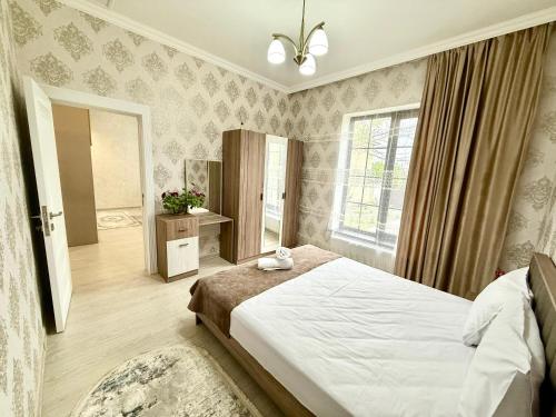 a bedroom with a large bed and a mirror at Samall new villa FRHD in Gabala