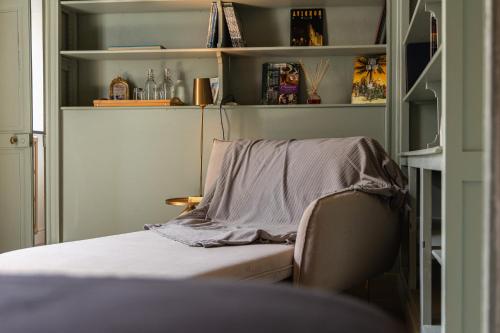 a room with a chair with a blanket on it at La Chapelle sur la Sorgue in LʼIsle-sur-la-Sorgue