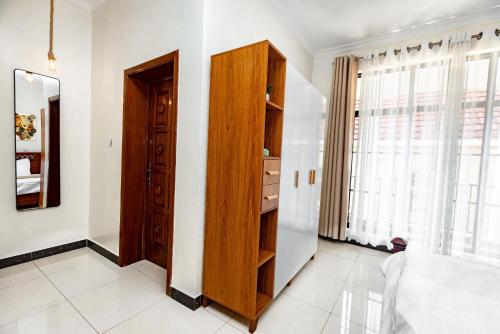 a bedroom with a wooden cabinet and a window at kigali Pillar House inn in Kigali