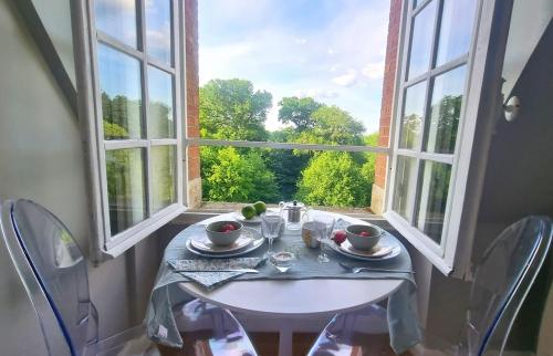 une table avec deux chaises et une table blanche avec une fenêtre dans l'établissement Beautiful suite in a historical castle in Loire Valley, à Salbris