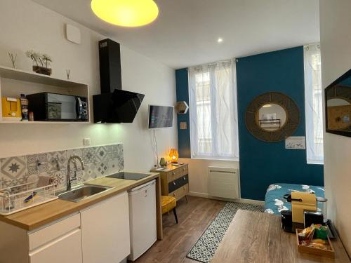 - une cuisine avec un évier et un bureau dans la chambre dans l'établissement Chez Jean-Yves et Zoé - LA BOHÈME - Au calme, Très propre, Proche parkings, à Niort