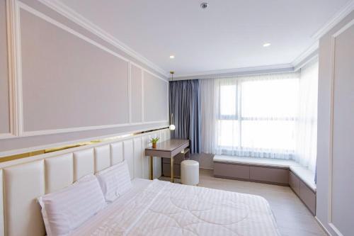 a bedroom with a large white bed and a window at Erica's House - Oceanview The Sóng Apartment Vũng Tàu Nghỉ Dưỡng Biển Cao Cấp 5 Sao - The Song Vung Tau Condotel 5 Star Beach View Apartment in Vung Tau