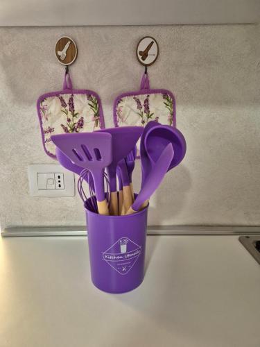 a purple cup filled with utensils on a counter at CASA BAT in Mantello