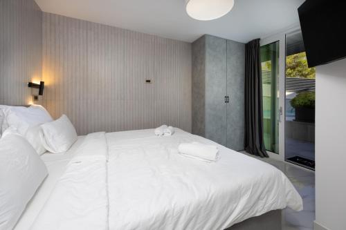 a large white bed in a room with a window at Hotel - Teranea City Hvar in Hvar