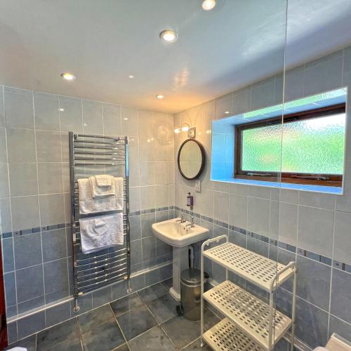 a bathroom with a sink and a mirror at Whitley Coach House in Whitley