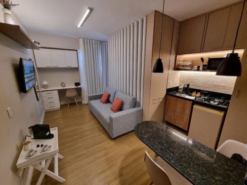 a small living room with a couch and a kitchen at Flat Condomínio Garden Park by CentoEdez in Brasilia