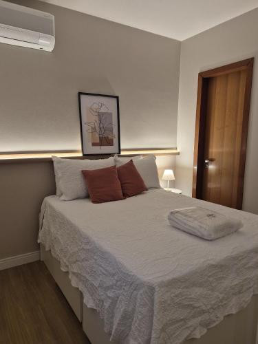 a bedroom with a large bed with two pillows at Flat Condomínio Garden Park by CentoEdez in Brasília