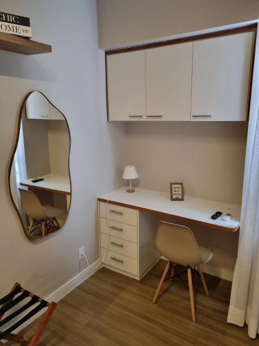 a room with a desk with a mirror and a chair at Flat Condomínio Garden Park by CentoEdez in Brasília
