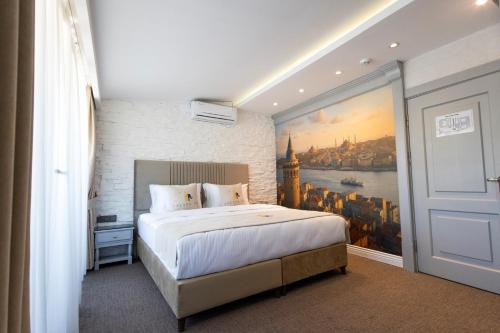 a bedroom with a large bed with a painting on the wall at Galata Fil Hotel in Istanbul