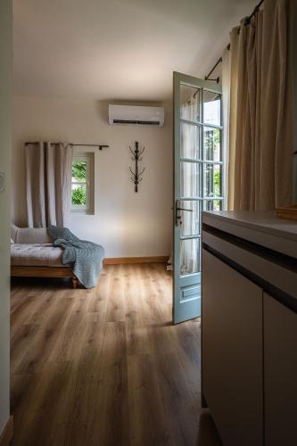 a living room with wooden floors and a door at La Chapelle sur la Sorgue in LʼIsle-sur-la-Sorgue