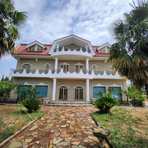 a large white house with a red roof at REZIDENCA ARBNORE - Tre Horizonte in Koplik