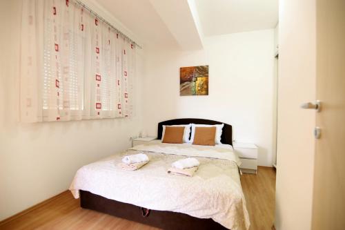 a bedroom with a bed with two towels on it at ILIEVSKI apartment 8 in Kumanovo