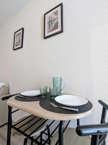 une table avec des assiettes et des verres au-dessus dans l'établissement Studio centre ville proche gare, à Roanne