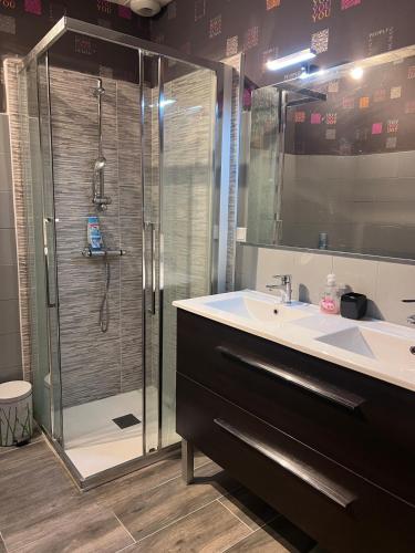a bathroom with a glass shower and a sink at Maison de ville in Cognac