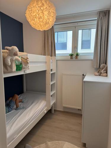 a childs room with a bunk bed and windows at Beach Addict Appartment Duinrust in Knokke-Heist
