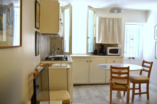 eine Küche mit einem Tisch, 2 Stühlen und einem Tisch in der Unterkunft Charmante maison centre historique d'Arles in Arles