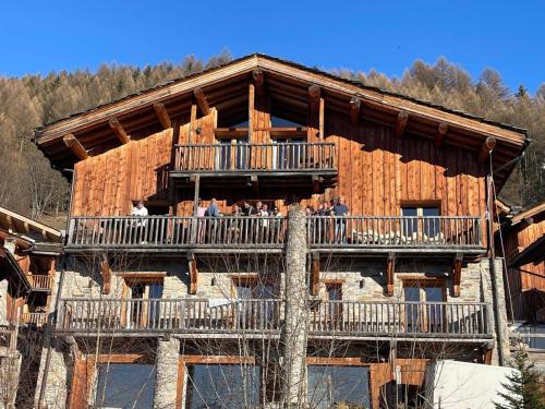 a group of people on the balcony of a log cabin at NEW Luxury Chalet Sapins - PRIVATE POOL- Mountains VIEW - Family & Comfort - SPECIAL LAUNCH OFFER in Sainte-Foy-Tarentaise
