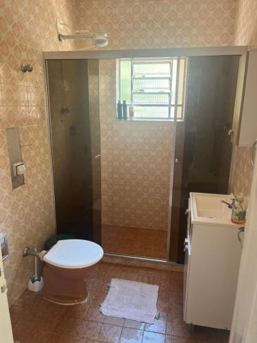 a bathroom with a shower and a toilet and a sink at Casa com Ar condicionado a 50m da praia de Riviera in Bertioga