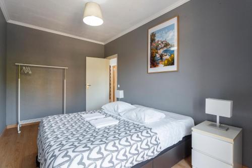 a bedroom with a bed and a picture on the wall at Casa da Linha in Cascais