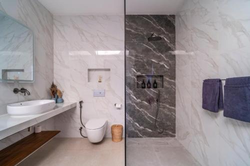 a bathroom with a shower and a toilet and a sink at Jago Gili Air in Gili Islands