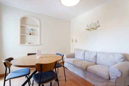 a living room with a table and a couch at Casa da Linha in Cascais