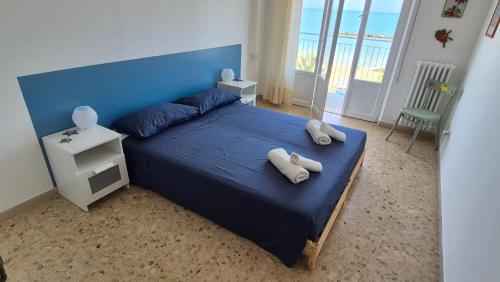a bedroom with a blue bed with two towels on it at Appartamento sul mare via Colombo in Grottammare