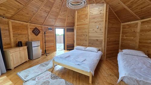 Dos camas en una habitación con paredes de madera. en Twins Yurt, en Kaji-Say