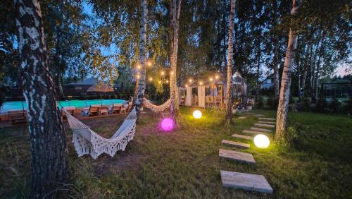 a backyard with hammocks in the trees at night at Domek Zielone Marzenie in Chrzanów