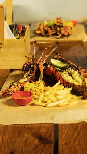 a plate of seafood and chips on a wooden table at Viva O Sonho 