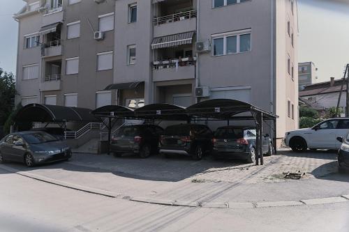 a parking lot with cars parked in front of a building at ILIEVSKI apartment 8 in Kumanovo