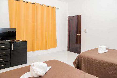 a hotel room with two beds and a television at Casa May May in Cobá