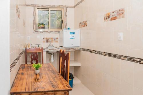 a small kitchen with a wooden table and a sink at Casa May May in Cobá