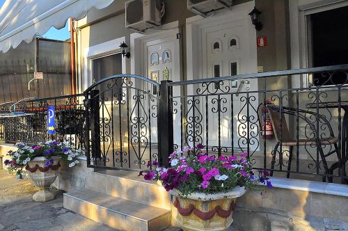 a building with two potted flowers on the stairs at Studios Kostas & Despina in Lidia