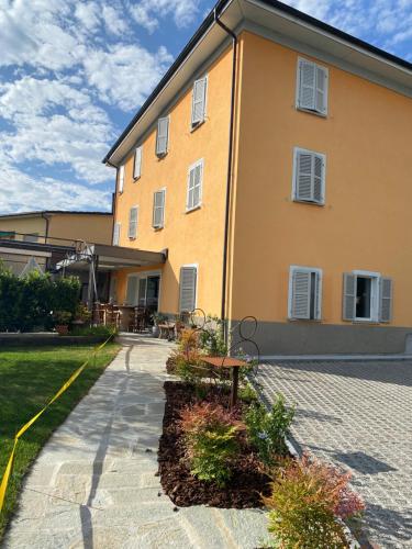 BalernaAlbergo Ristorante Stazione Balerna的前面有长凳的黄色建筑