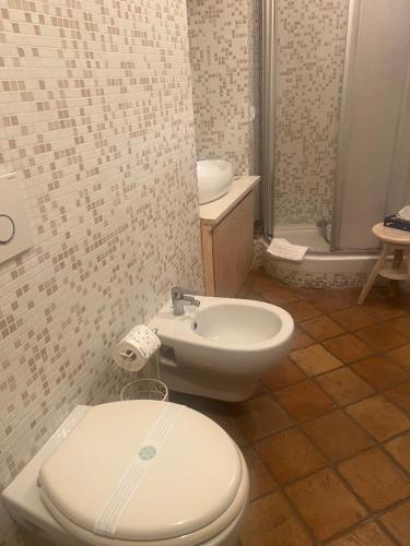 a bathroom with a white toilet and a sink at Marieta Rooms in Sarzana