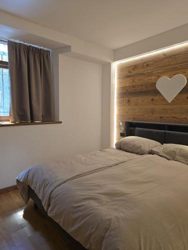 a bedroom with a bed with a heart on the wall at Dolomiten Lounge - moderno con parcheggio privato in Pergine Valsugana