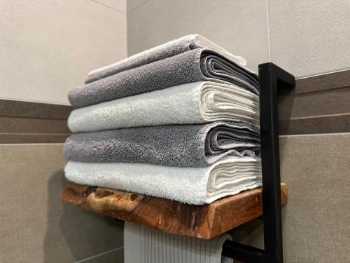 a stack of towels on a wooden rack in a bathroom at Chez Gaston - Entrelacs in Pouilly