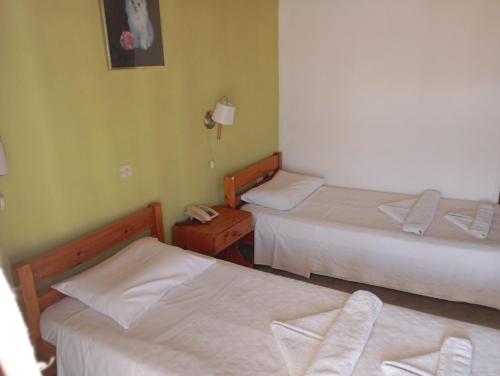 a hotel room with two beds and a phone at Hotel Mariboni in Samos