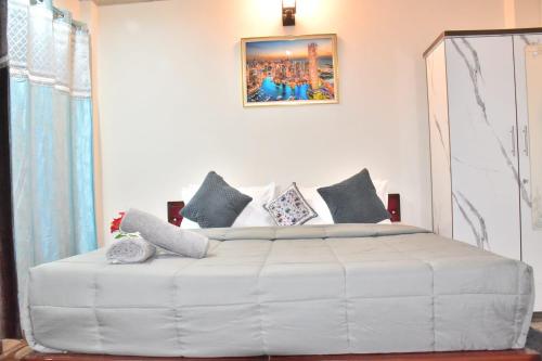 a bedroom with a large white bed with pillows at A Greenwoods Hotel in Solan