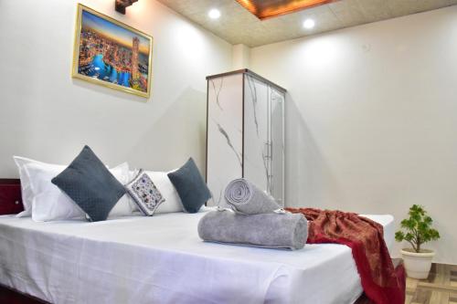 a bedroom with a bed with white sheets and pillows at A Greenwoods Hotel in Solan