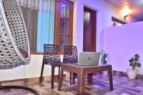 a room with a table with a laptop on it at A Greenwoods Hotel in Solan